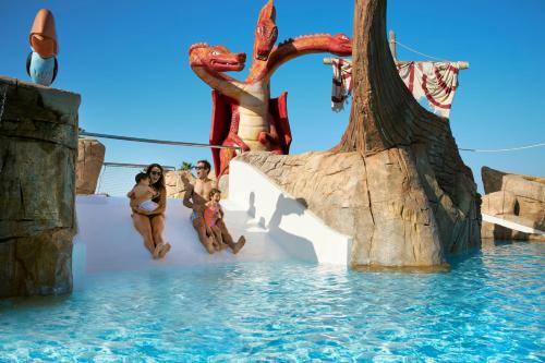 a group of people sitting on a water slide at a water park at Iberostar Waves Royal Andalus in Chiclana de la Frontera