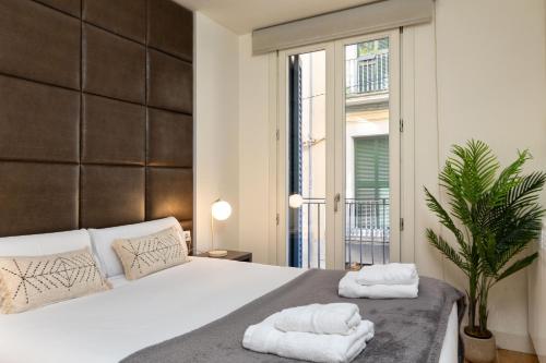a bedroom with a bed with towels on it at Flateli Nord in Girona