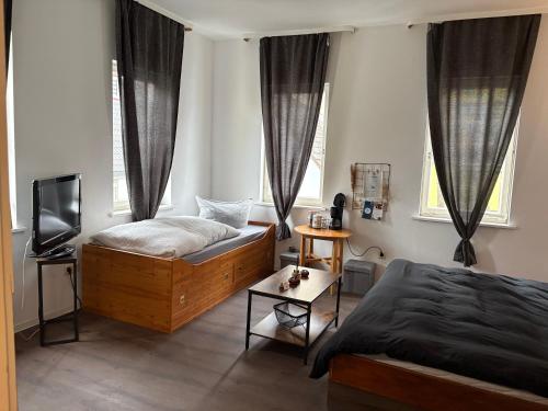 a bedroom with two beds and a television in it at Junges Wohnen zwei in Weikersheim