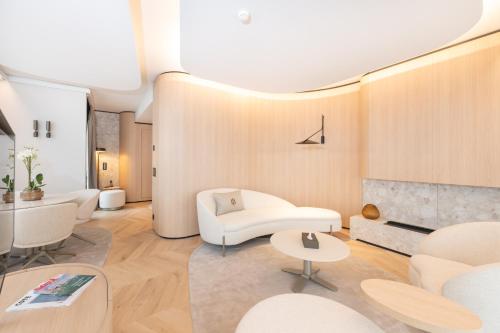a living room with white furniture and a fireplace at Hôtel des Innovations - Hôtel & Appartements - Votre séjour entre Fribourg, ville médiévale et La Gruyère et ses Bains in Marly-le-Grand