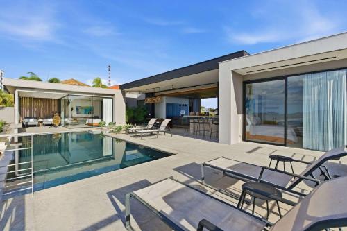 a house with a swimming pool and a patio at Infinity Pool Villa , 4 Suites & Private Casita in Tamarindo