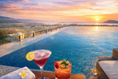 a drink sitting on a table next to a pool at Luxury Suites by Eden Wellness and Hospitality in Dehradun