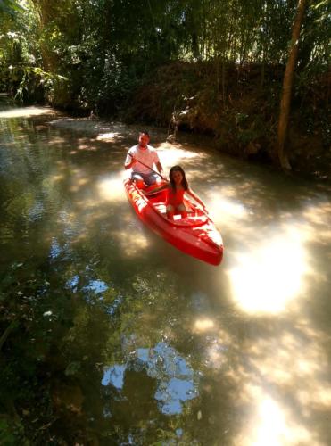a man and a woman in a red kayak on a river at Camping le beauvillage Lauzerte in Lauzerte