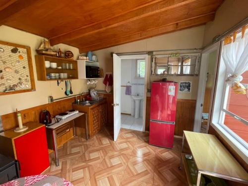 a kitchen with a red refrigerator in a room at Cabaña Lago Puyehue in Mantilhue