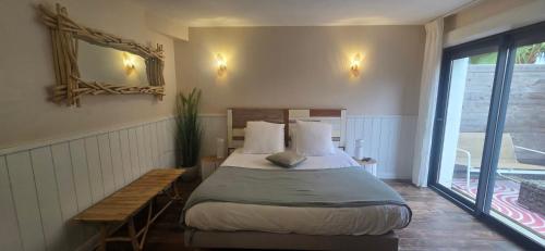 a bedroom with a bed and a bench and a window at La Perle du Voyageur in Agde