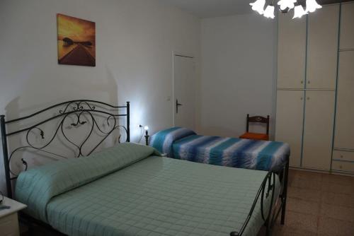 a bedroom with two beds with blue sheets at Villa Alessandro in Poggiardo