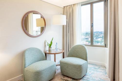 a room with two chairs and a table and a mirror at Crowne Plaza Porto by IHG in Porto