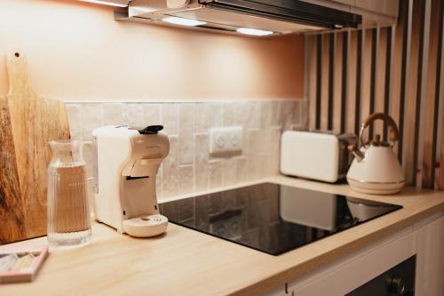 a kitchen counter with a coffee maker on a counter top at Le Spa by SCH in Le Havre