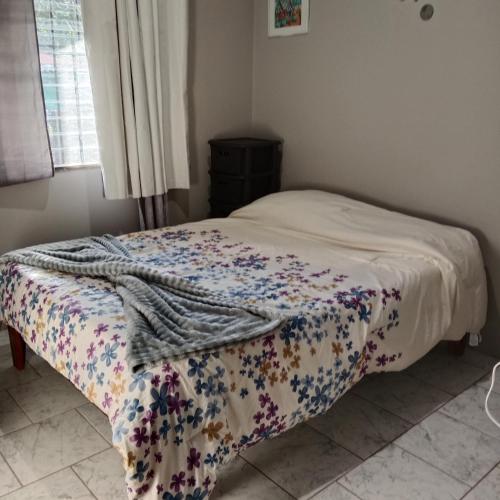 a bed with a blanket on it in a bedroom at Pacific villa lisn in Nicoya