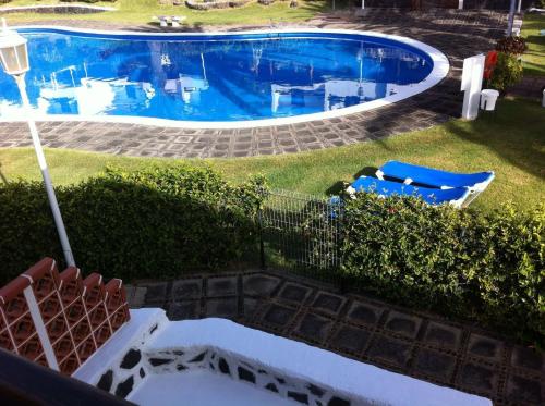 an overhead view of a swimming pool with two blue chairs at VV Duplex Isla Bonita "by henrypole home" in Los Cancajos