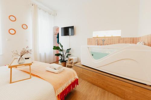 a bedroom with a tub and a bed with a table at Le Spa by SCH in Le Havre