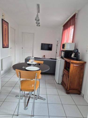 un soggiorno con tavolo e cucina di Chambre Is a Is-sur-Tille