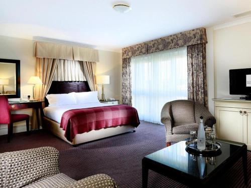 a hotel room with a bed and a living room at Macdonald Botley Park Hotel & Spa in Southampton