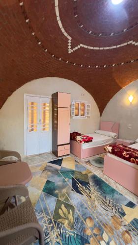 a room with two beds and a ceiling at Nour El wadi in Siwa