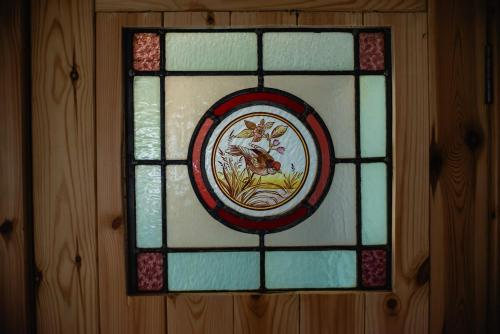 a stained glass window with a bird on it on a wall at The Truck in Longframlington