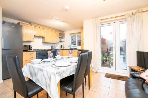 a kitchen and dining room with a table and chairs at 6 bed house with free secure parking & 3 bathrooms in Wolverhampton
