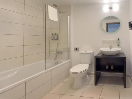 a white bathroom with a toilet and a sink at SOL by Meliá Dunas Family Fun in Santa Maria