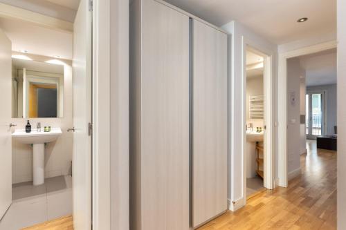 a white bathroom with a sink and a mirror at Flateli Nord in Girona