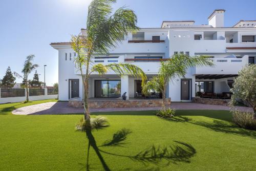 a large white building with a green yard at Serenity Garden & Spa in Los Alcázares