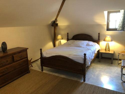 a bedroom with a bed and a dresser and two lamps at Le relais de la motte in Thuré