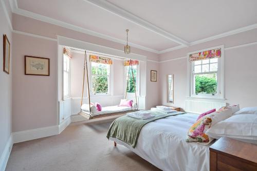 a white bedroom with a large bed and windows at Old Ford House in Blandford Forum