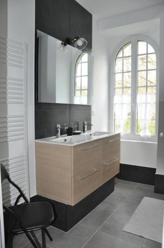 a bathroom with a sink and a chair in it at Le moulin brûlé in Béthines
