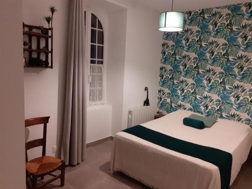 a bedroom with a bed and a floral wallpaper at Le moulin brûlé in Béthines