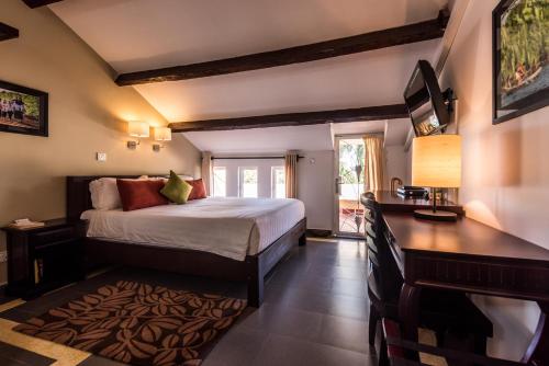 貢布的住宿－克羅姆酒店，一间卧室配有一张床、一张书桌和一台电视