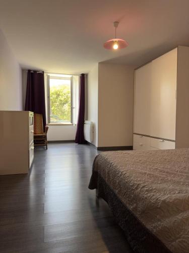 a hotel room with a bed and a window at Gîte des voines in Maillé