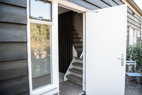 an open door to a house with a mirror at Sfeervol appartement voor 2 personen De Jonge Blomme in Kamperland