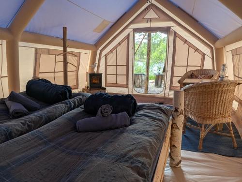 a large bed with pillows on it in a room at Vristulvens Glamping in Mariestad