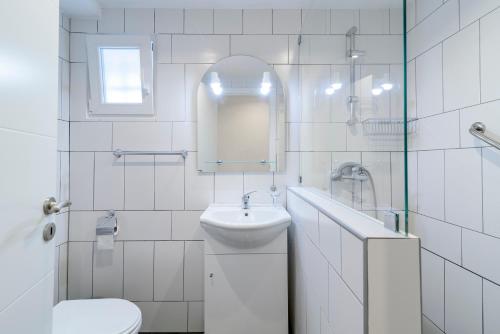 bagno bianco con lavandino e servizi igienici di Carvoeiro Beach Apartment Luxury a Carvoeiro