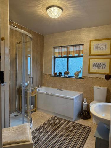 a bathroom with a tub and a toilet and a sink at Orchard Side Bed and Breakfast in Great Malvern