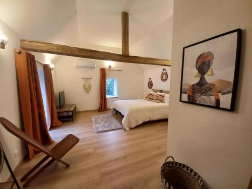 a bedroom with a bed and a painting on the wall at Domaine la jarrie in La Bussière