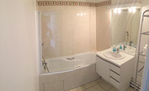 La salle de bains est pourvue d'une baignoire, d'un lavabo et d'une douche. dans l'établissement Appartement near Disneyland, à Serris