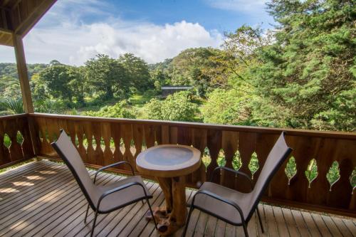 a deck with a table and two chairs and a table at Cabañas Hoja Verde in Monteverde Costa Rica
