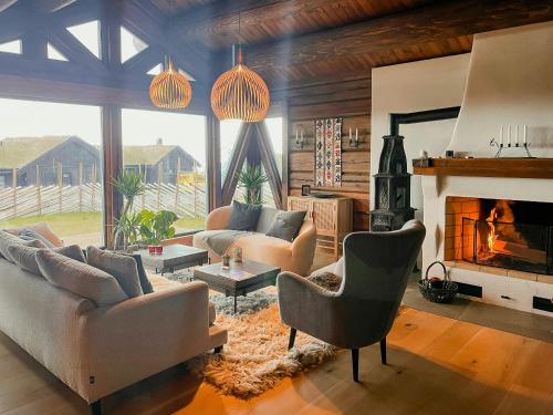a living room with two couches and a fireplace at Log Cabin With Views Over Turufjell in Flå