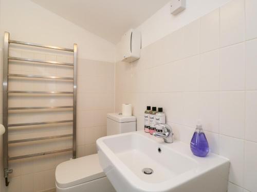a white bathroom with a sink and a toilet at 3 The Stoneyard in Bath