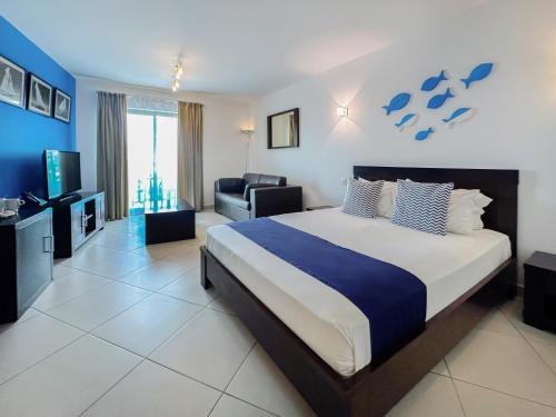 a bedroom with a large bed and a living room at SOL by Meliá Dunas Family Fun in Santa Maria