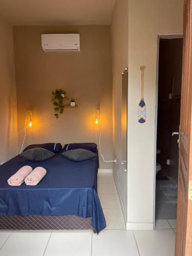 a bedroom with a blue bed with two pink pillows at Pouso Clara Mar in Paraty