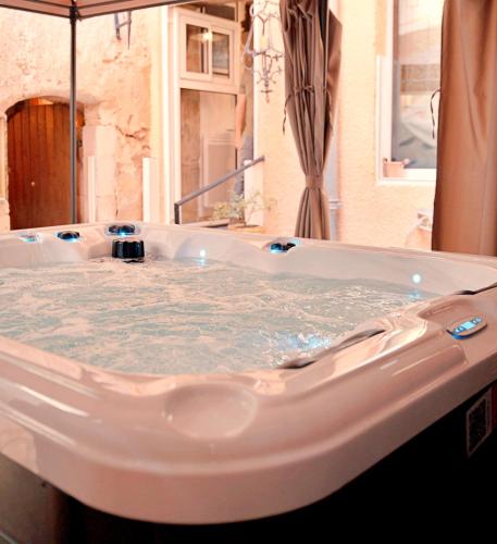 eine mit Wasser gefüllte Badewanne in einem Badezimmer in der Unterkunft Le1693 - Charme & confort 4 étoiles - Jacuzzi in Limoux