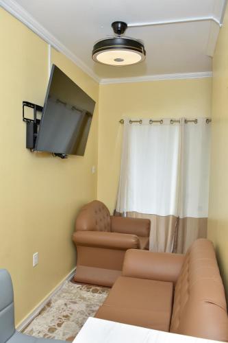 a living room with a couch and a flat screen tv at Duncan Street Guesthouse in Georgetown