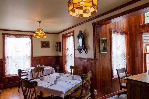 a dining room table and chairs in a room at Auberge Mr James in Rivière-du-Loup