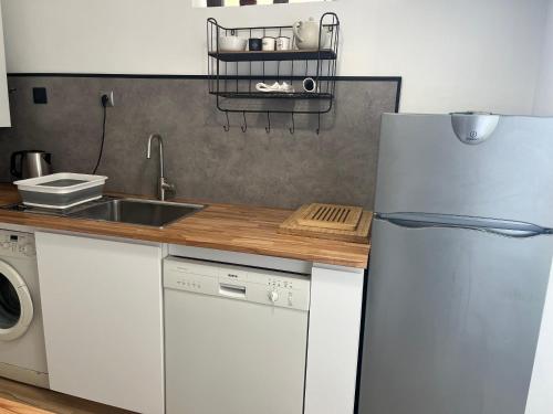a kitchen with a white refrigerator and a sink at Le Face à La Mer in Ajaccio