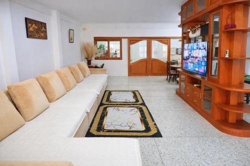 a living room with a white couch and a tv at Sukhumvit 81 Haven House- BTS Onnut in Bangkok