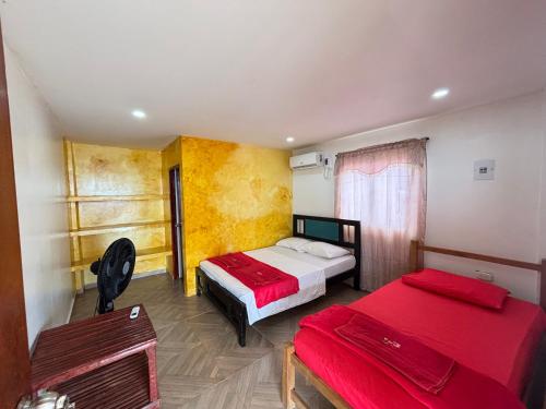 two beds in a room with red sheets at Refugio Pantu in Cabo de la Vela