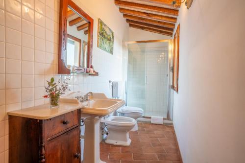 a bathroom with a sink toilet and a mirror at La Corte Medicea in Montepulciano