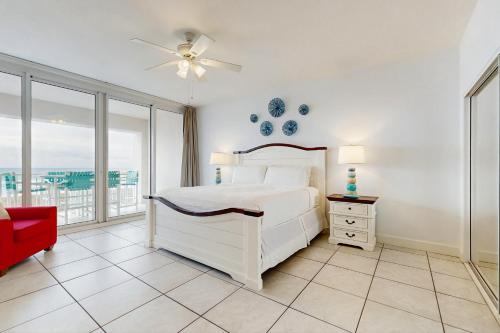 a bedroom with a white bed and a red chair at Navarre Beach Regency 203 in Navarre