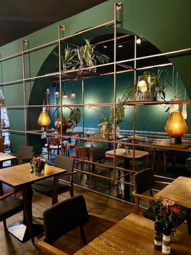a restaurant with tables and chairs and plants on the wall at Hotel Brasserie de Huifkar in Middelburg