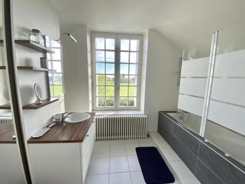 a bathroom with a sink and a tub and a window at Les forts in Leigné-les-Bois